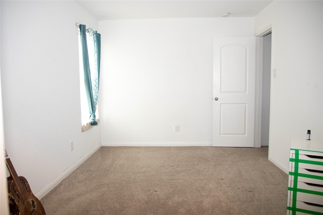 carpeted spare room with baseboards