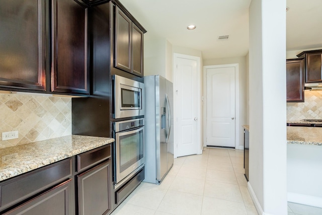 kitchen with light tile patterned flooring, visible vents, appliances with stainless steel finishes, backsplash, and light stone countertops