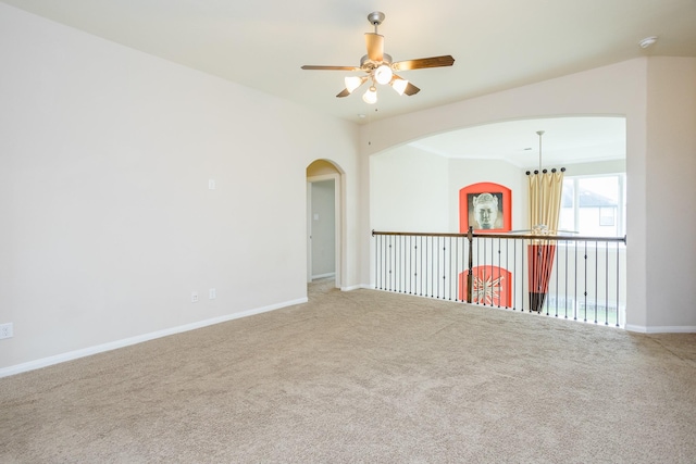 spare room with carpet floors, a ceiling fan, and baseboards