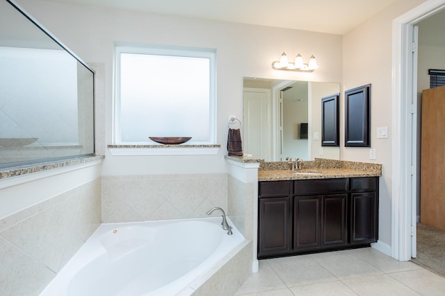 bathroom with vanity, a bath, and tile patterned floors