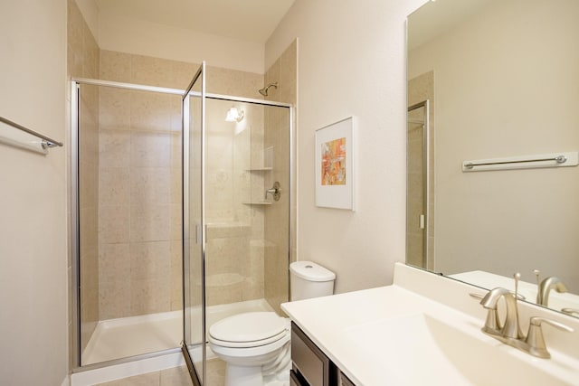 full bathroom featuring tile patterned flooring, a shower stall, toilet, and vanity