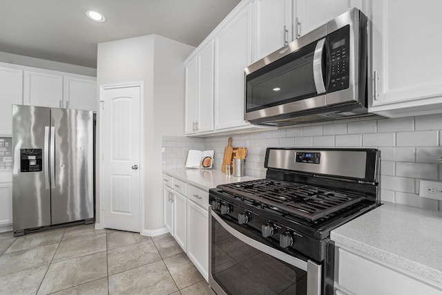 kitchen with light tile patterned floors, stainless steel appliances, backsplash, and white cabinets