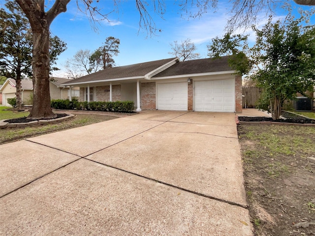 single story home with a garage, driveway, brick siding, and fence