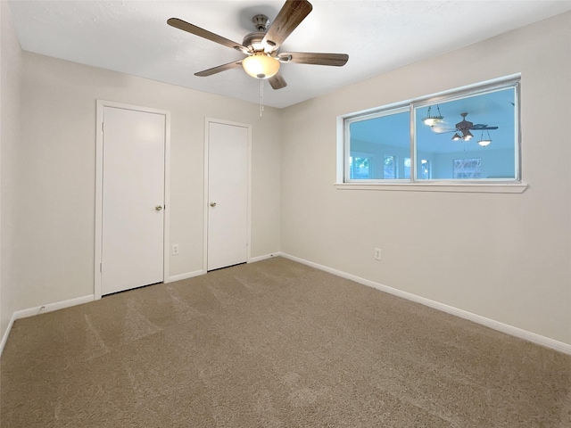 unfurnished bedroom with carpet flooring, ceiling fan, and baseboards