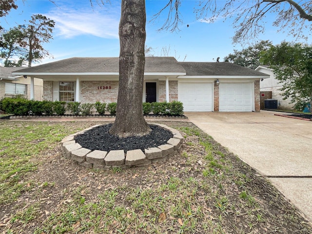 ranch-style home featuring brick siding, driveway, an attached garage, and central air condition unit