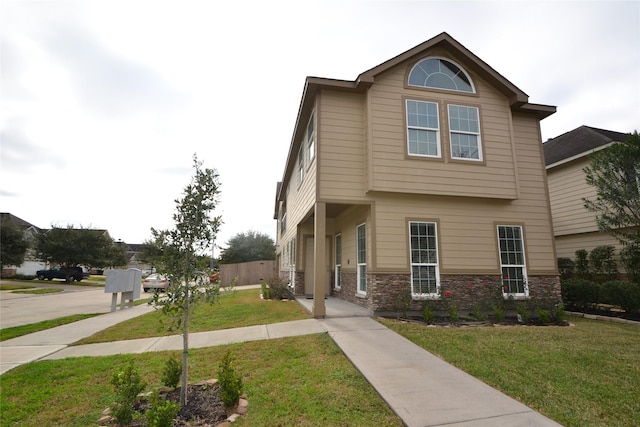 view of front of home featuring stone siding and a front lawn