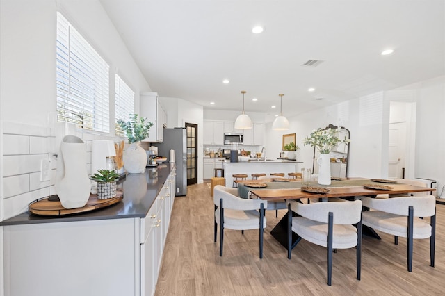 dining space featuring recessed lighting, visible vents, and light wood-style floors