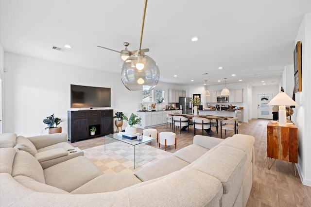 living room featuring recessed lighting, light wood-style floors, and visible vents