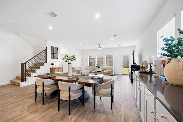 dining area featuring a wealth of natural light, visible vents, stairway, and light wood-style floors