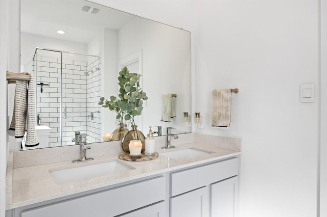 full bath with double vanity, visible vents, a stall shower, and a sink