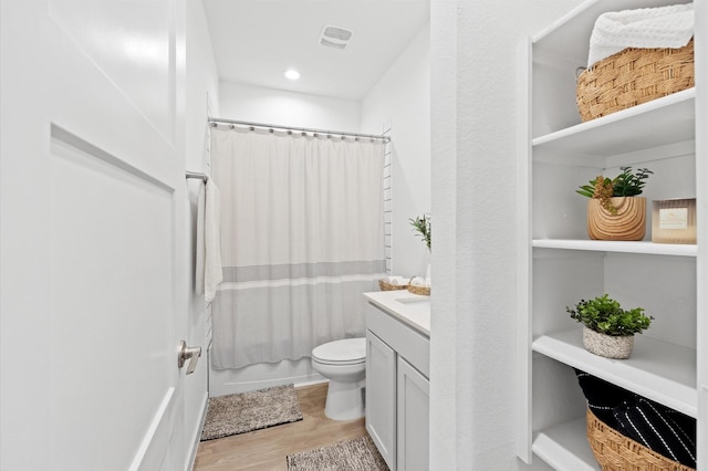 full bathroom featuring vanity, toilet, wood finished floors, and shower / tub combo with curtain