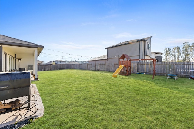 view of yard with a fenced backyard and a playground