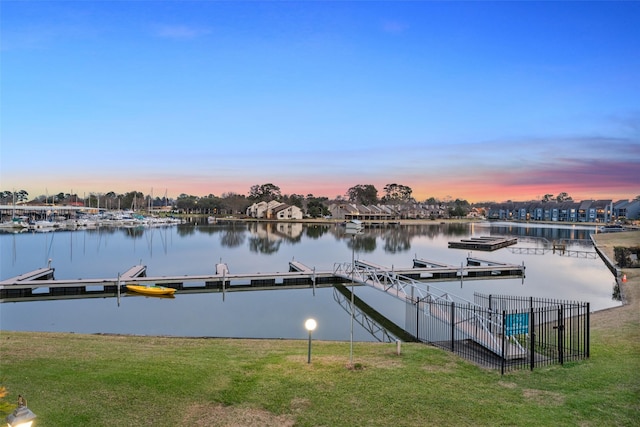 view of dock featuring a lawn and a water view