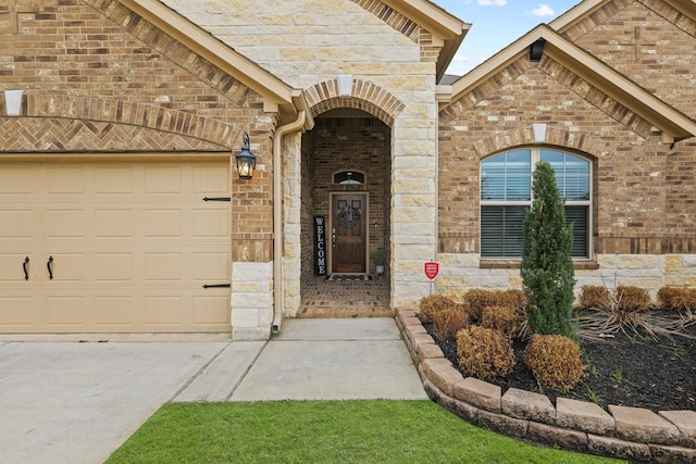 property entrance with concrete driveway, an attached garage, and brick siding