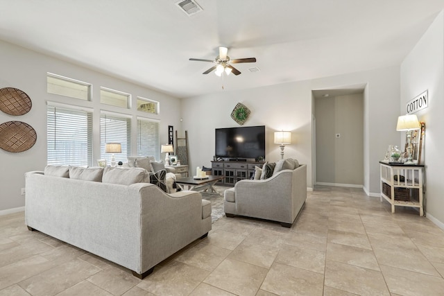 living area with baseboards, visible vents, and ceiling fan