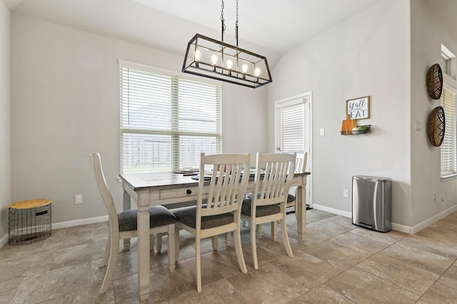 dining space with an inviting chandelier, baseboards, and vaulted ceiling