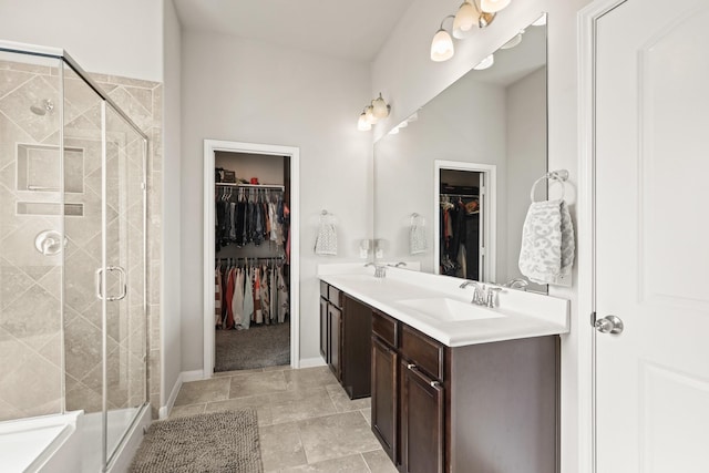 bathroom featuring a shower stall, double vanity, and a sink