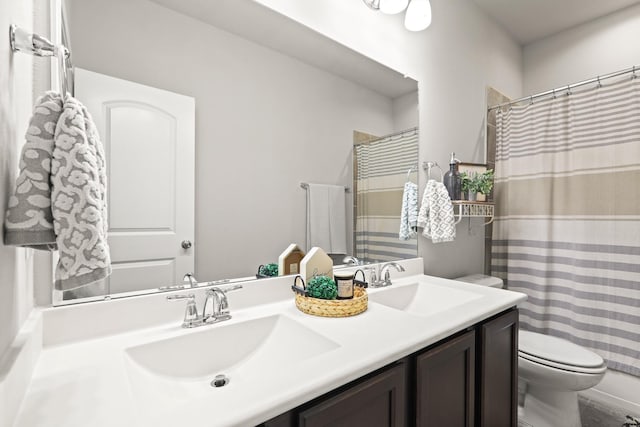 bathroom with a sink, curtained shower, toilet, and double vanity