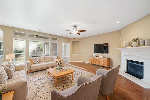 living room featuring ceiling fan, recessed lighting, wood finished floors, visible vents, and a glass covered fireplace