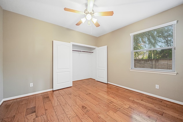 unfurnished bedroom with light wood-style floors, a closet, baseboards, and a ceiling fan