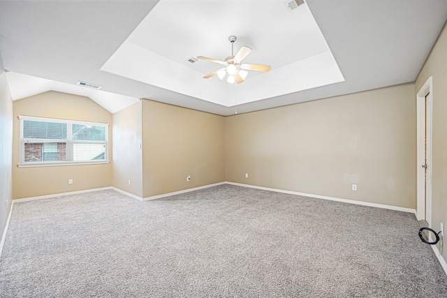 carpeted spare room with baseboards, visible vents, a raised ceiling, and a ceiling fan