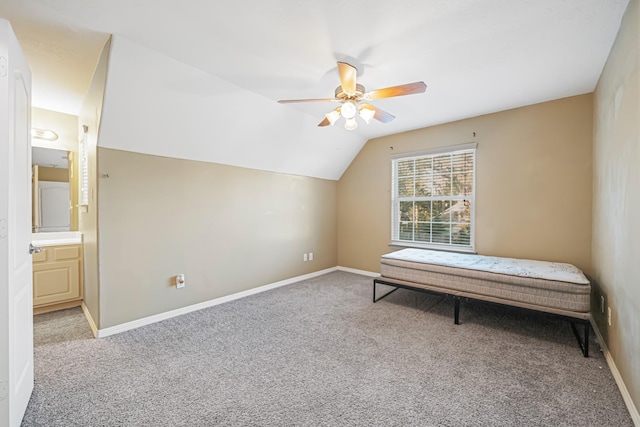 unfurnished bedroom featuring baseboards, a ceiling fan, lofted ceiling, ensuite bath, and carpet floors