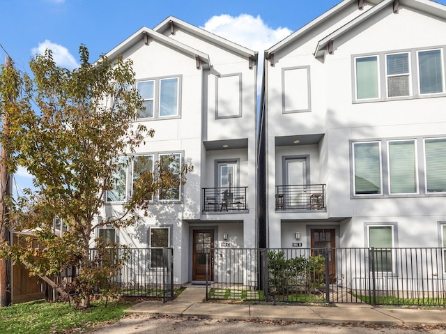 multi unit property with a fenced front yard and stucco siding