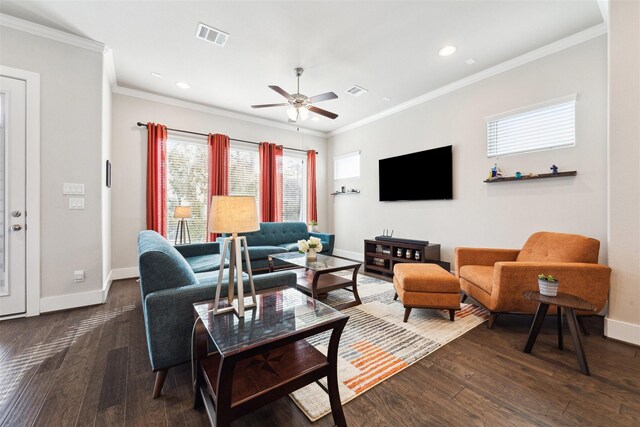 living room with ornamental molding, wood finished floors, visible vents, and baseboards