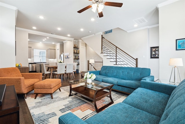 living room featuring ornamental molding, stairway, visible vents, and recessed lighting