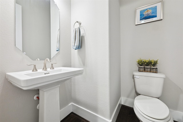 bathroom with baseboards, a sink, and toilet