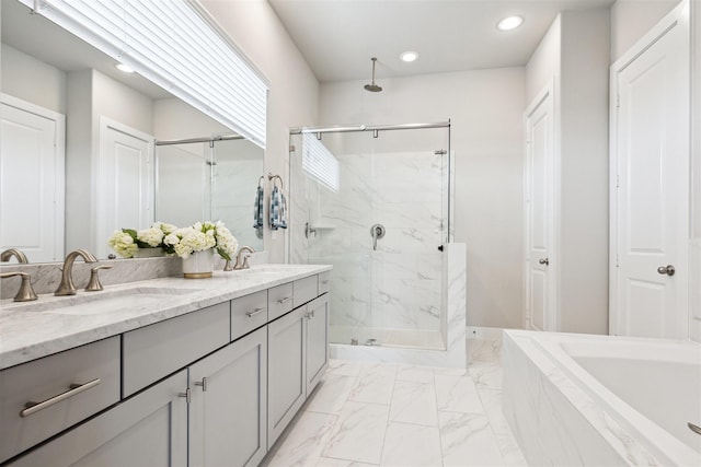 full bathroom featuring a garden tub, a sink, marble finish floor, a marble finish shower, and double vanity