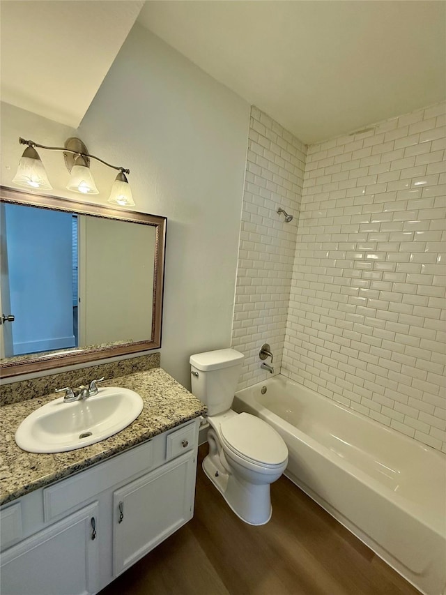 full bath featuring bathtub / shower combination, vanity, toilet, and wood finished floors