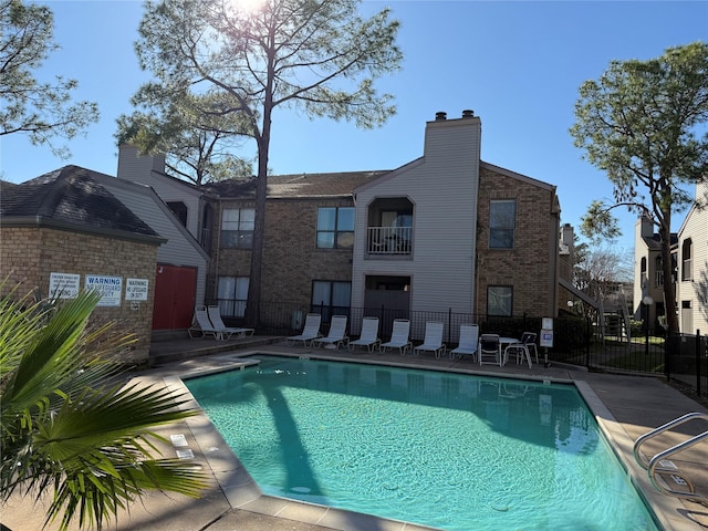 pool featuring fence and a patio