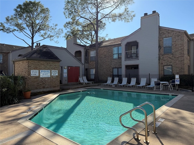 community pool featuring fence and a patio