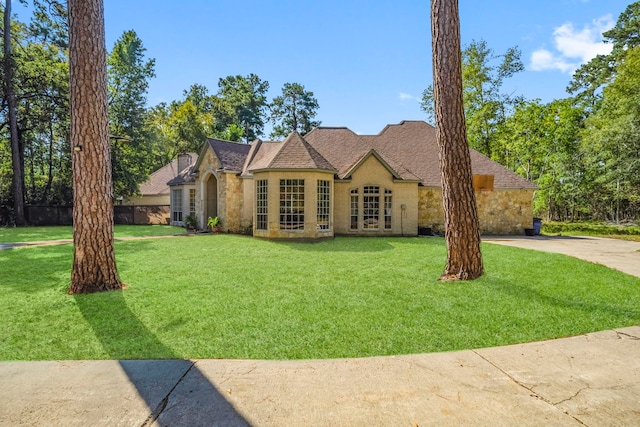 french country home with a front yard and stone siding