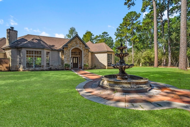 view of front of home featuring a chimney and a front yard