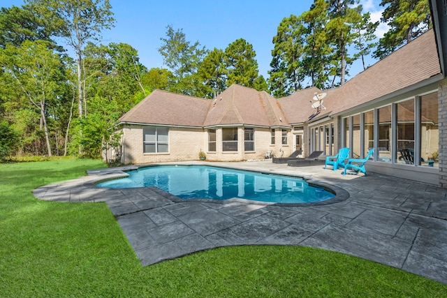 outdoor pool with a patio area and a yard