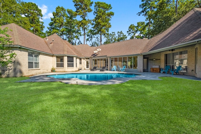 pool with a patio area and a lawn