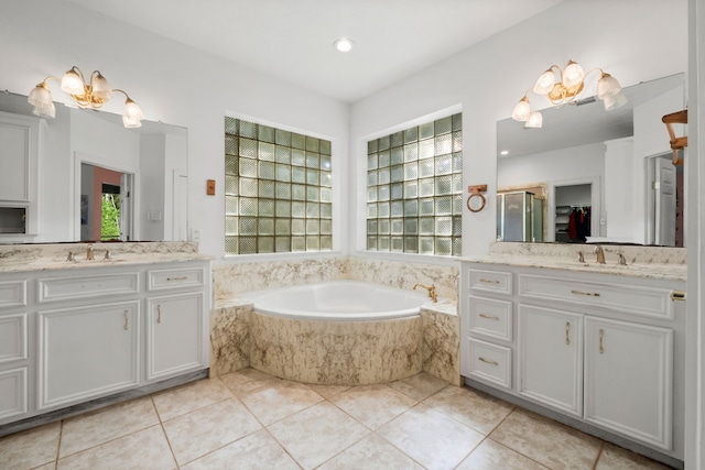 full bathroom with two vanities, a sink, and a garden tub
