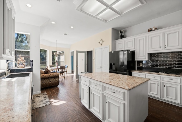 kitchen with tasteful backsplash, wood finish floors, a sink, and black appliances