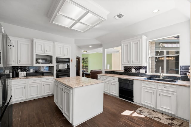 kitchen featuring black appliances, visible vents, white cabinets, and a sink