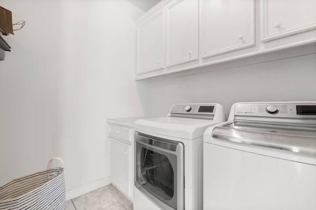 washroom featuring cabinet space, baseboards, light tile patterned flooring, and independent washer and dryer