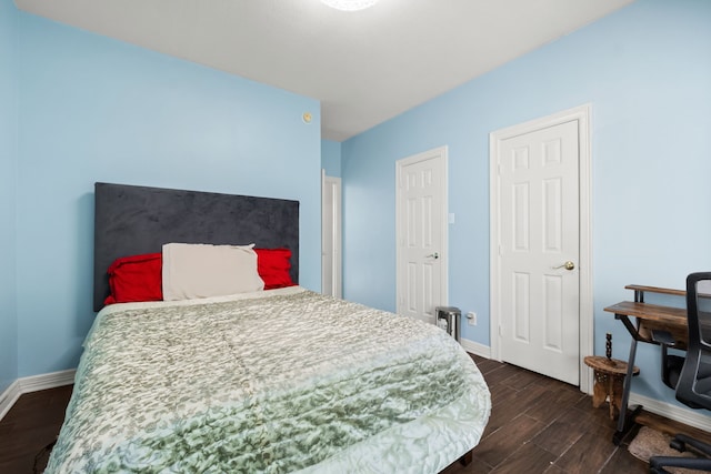 bedroom featuring dark wood-style flooring and baseboards