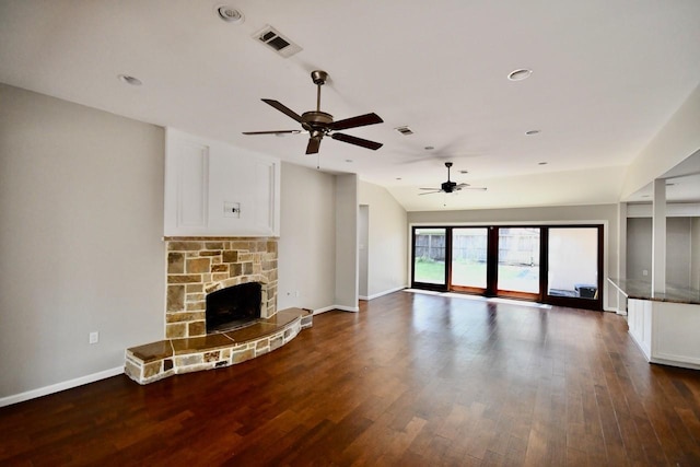 unfurnished living room with visible vents, a stone fireplace, and wood finished floors