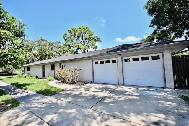 single story home with a garage, brick siding, fence, concrete driveway, and a front lawn