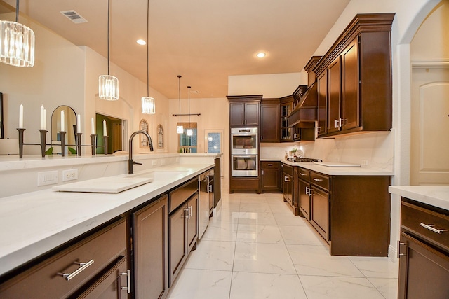 kitchen featuring visible vents, marble finish floor, pendant lighting, a sink, and appliances with stainless steel finishes