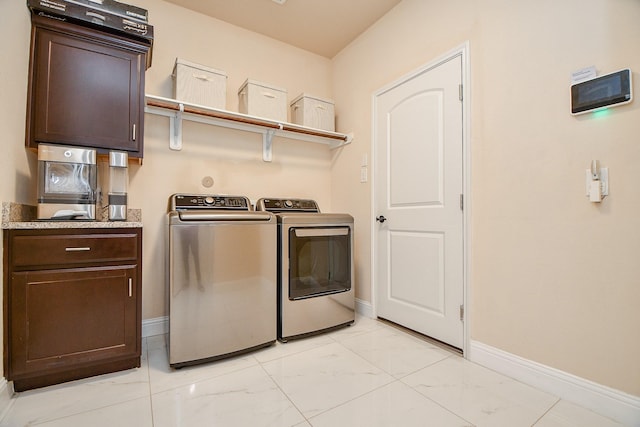 clothes washing area with washer and clothes dryer, marble finish floor, cabinet space, and baseboards