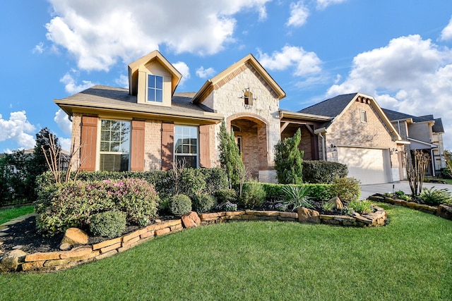 view of front of property featuring a front yard, concrete driveway, a garage, stone siding, and brick siding