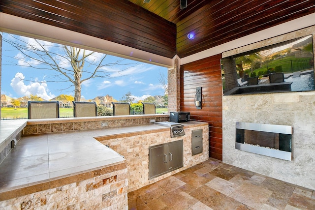 view of patio / terrace with exterior kitchen and a grill