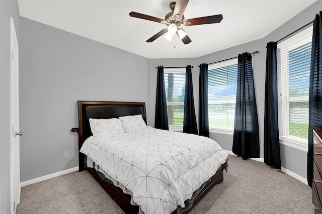 bedroom with a ceiling fan, baseboards, and carpet flooring